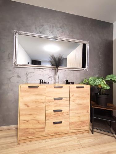 a mirror above a wooden dresser in a room at Apartment Aby - Free Parking & Self Check-in in Slavonski Brod