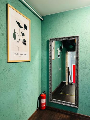 a mirror on a green wall in a room at Apart-Hotel IGORIVSKA in Kyiv