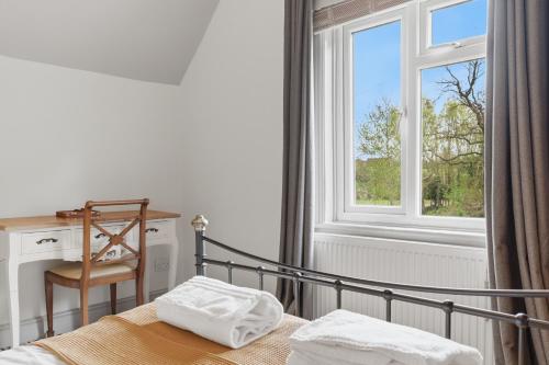 a bedroom with a bed and a desk and a window at 2-Bedroom Cottage Sleeps 5 Free Parking in Harlow