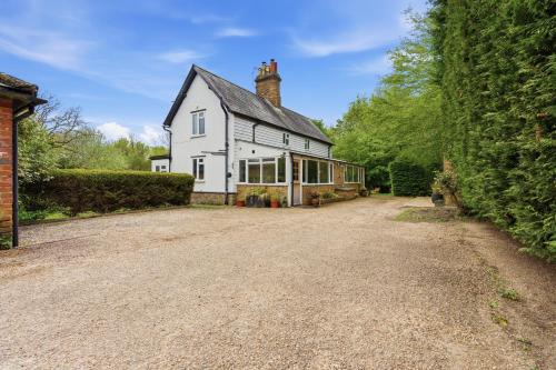 a large white house with a large driveway at 2-Bedroom Cottage Sleeps 5 Free Parking in Harlow