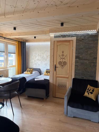 a room with two beds and a table and chairs at U Marysi i Jacka in Murzasichle