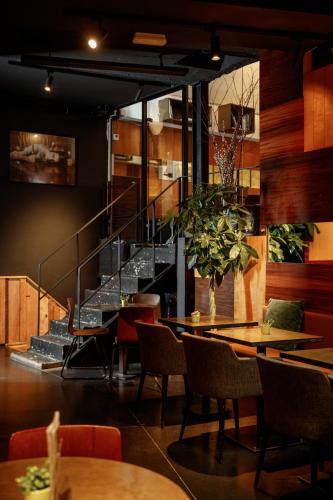 a restaurant with tables and chairs and a staircase at HotelO Kathedral in Antwerp
