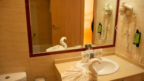 a bathroom with a sink and a mirror at Hotel-Apartamento Las Olas in Los Cancajos