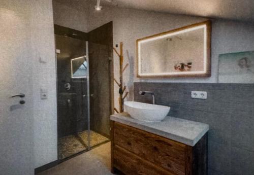 a bathroom with a sink and a shower at Das Alpenhostel in Brannenburg