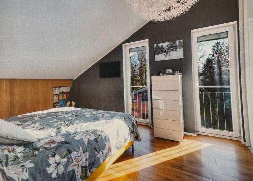 a bedroom with a bed and some windows at Das Alpenhostel in Brannenburg