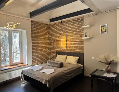 a bed in a room with a brick wall at Apart-Hotel IGORIVSKA in Kyiv