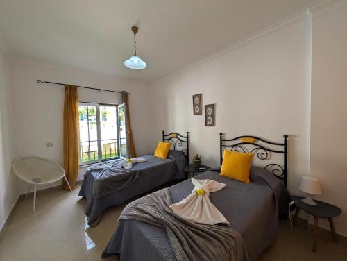 a bedroom with two beds and a window at 5B Sra da Rocha - Casas & Papeis in Armação de Pêra