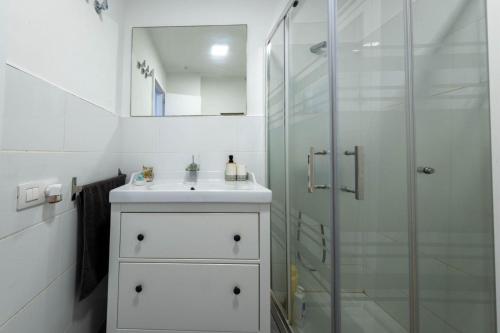 a white bathroom with a sink and a shower at Casa Atardecer in Moya