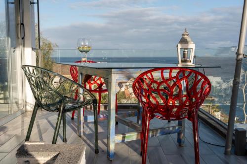 a balcony with a glass table and two chairs at "El Ático Bonito"-Penthaus-Whirlpool-Atlantikblick in Las Playitas