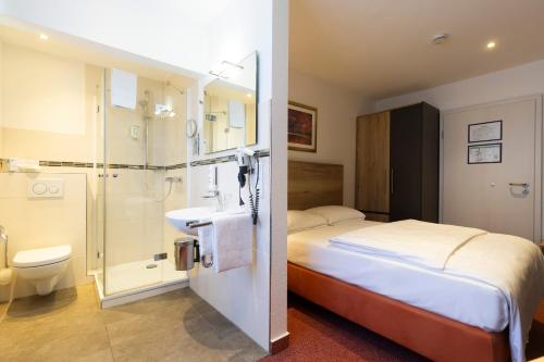 a bedroom with a bed and a sink and a shower at Mariaweiler Hof in Düren - Eifel