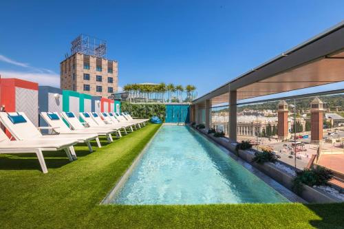 a pool on the roof of a building with lounge chairs at Occidental Barcelona 1929 in Barcelona