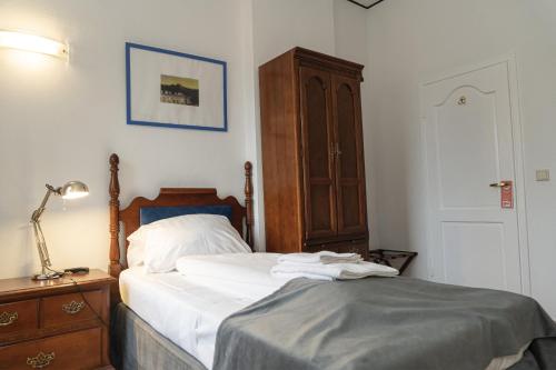 a bedroom with a bed and a dresser with a lamp at Petit Wannsee GmbH in Berlin