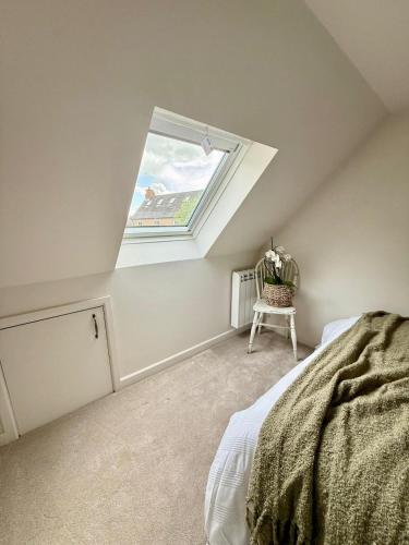 a bedroom with a skylight and a bed and a chair at Modern Cotswolds Studio in Bishops Cleeve