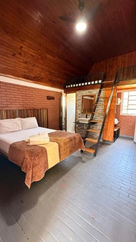 a bedroom with a bed and a staircase in it at Pousada e Camping Carrion in Itu