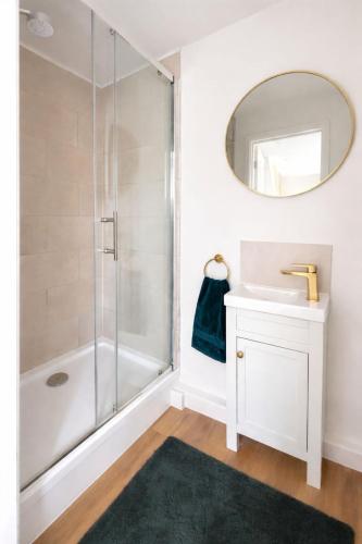 a bathroom with a shower and a sink and a mirror at Modern Cotswolds Studio in Bishops Cleeve