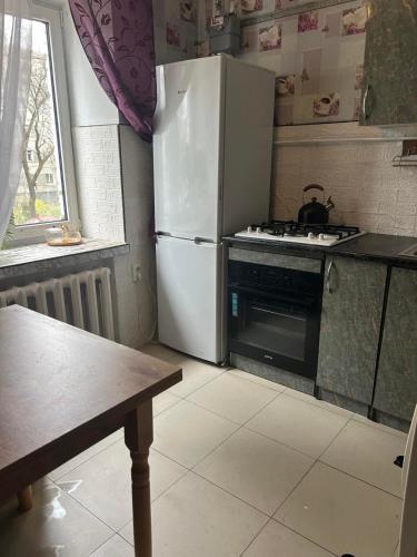 a kitchen with a white refrigerator and a stove at Затишна трьохкімнатна квартира у Львові in Lviv