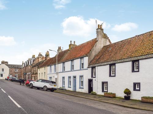 eine Reihe weißer Häuser am Straßenrand in der Unterkunft Ardvar in Crail