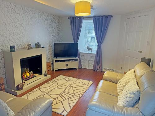 ein Wohnzimmer mit Sofa und Kamin in der Unterkunft Ardvar in Crail