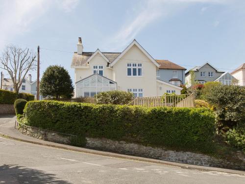 a white house with a hedge in front of a street at Berrystead Upper Flat in Salcombe