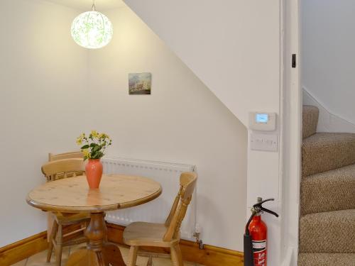 a room with a table with chairs and a staircase at Stockdale Cottage in Ambleside