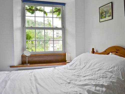 a white bedroom with a bed and a window at Stockdale Cottage in Ambleside