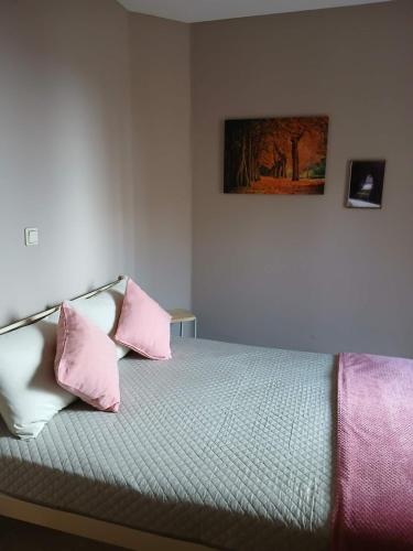 a bedroom with a bed with pink and white pillows at Blue Hour in Monemvasia