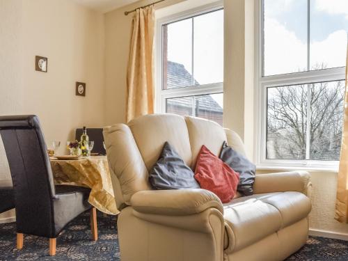 a living room with a couch with pillows on it at Whitby Apartment in Commondale
