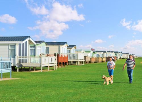 a man and a child walking a dog on the grass at Unity Skirlington Coast Yorkshire in Ulrome
