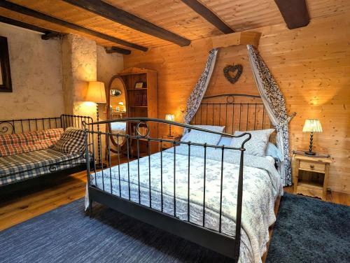 a bedroom with a bed and a couch in a room at Chambre Fleur bleue, les Volets Bleus in Laneuvelotte