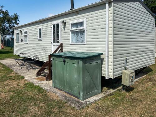 a white house with a trash can in front of it at 136 Lakeside in Burnham on Sea