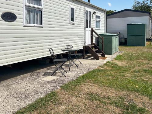 a table and chairs sitting next to a trailer at 136 Lakeside in Burnham on Sea