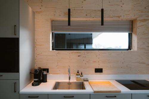 a kitchen with a sink and a window at Polderlodge de Verademing in Goudriaan