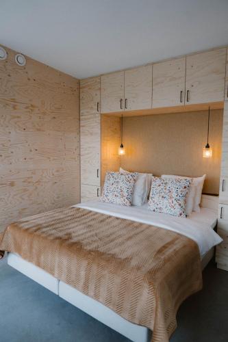 a bedroom with a large bed with wooden walls at Polderlodge de Verademing in Goudriaan