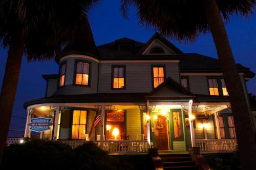 a house with an american flag on the porch at night at Pensacola Victorian Bed & Breakfast in Pensacola