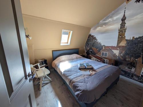 a bedroom with a bed and a window with a clock tower at Brasserie de Peperboom in Veere