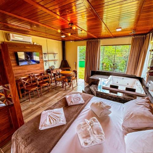 a bedroom with a large bed and a dining room at Pousada Via Láctea in Três Cachoeiras