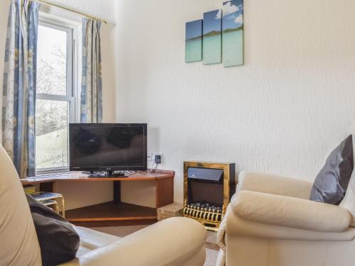a living room with a couch and a desk with a television at Farndale Apartment in Commondale
