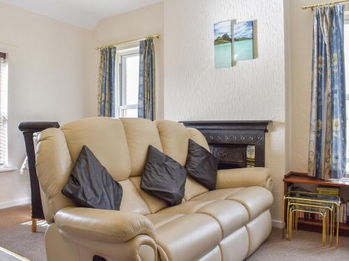 a living room with a leather couch with two pillows at Farndale Apartment in Commondale