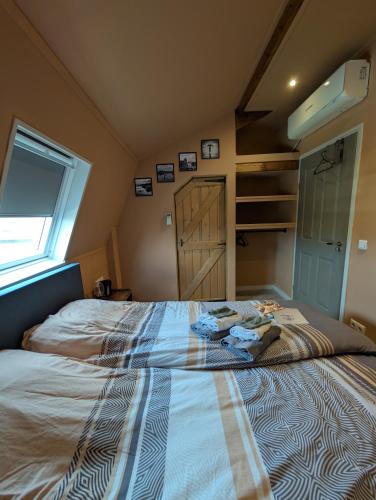 a large bed in a room with a window at Brasserie de Peperboom in Veere