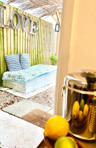 a porch with a bench with a bowl of fruit at Lily s Pad - Private retreat in Lymington, New Forest in Lymington