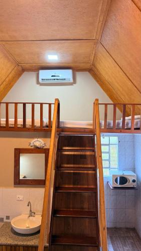 a staircase leading up to a bathroom with a sink at Pousada e Camping Carrion in Itu