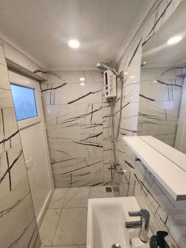 a white bathroom with a sink and a shower at Şehzade Apart Otel in Fethiye