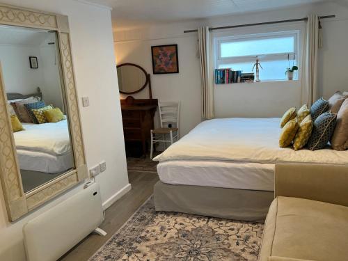 a bedroom with a mirror and a bed and a couch at Lily s Pad - Private retreat in Lymington, New Forest in Lymington