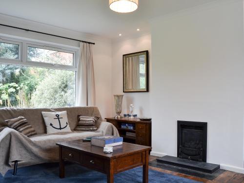 a living room with a couch and a fireplace at Sea Breezes in Totland