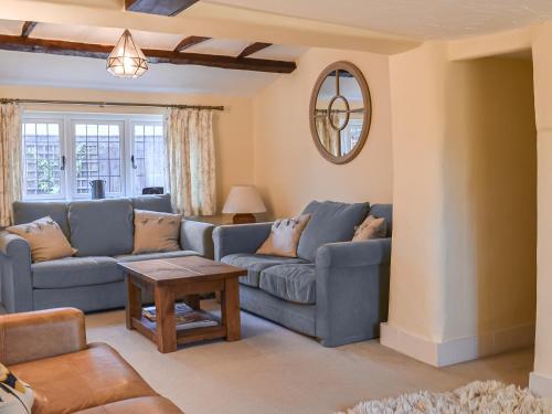 a living room with blue couches and a table at Flanders Cottage in Lymington
