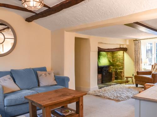a living room with a blue couch and a table at Flanders Cottage in Lymington