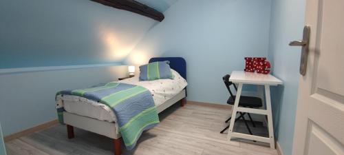 a small bedroom with a bed and a table at Bienvenue chez Céline in Mareuil-sur-Ourcq
