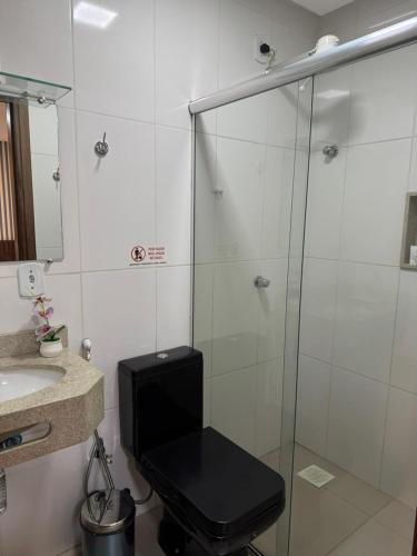a bathroom with a glass shower with a toilet at Hotel Universal in Santarém