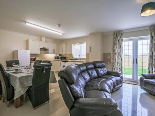 a living room with a leather couch and a table at 2 Dawson Court - Uk33411 in Mablethorpe