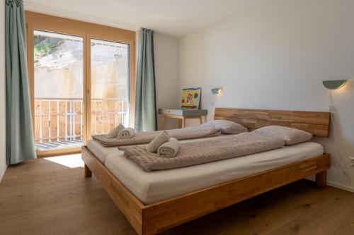 a bedroom with a bed with a large window at Gommer Sunna - Joderestutz in Reckingen - Gluringen